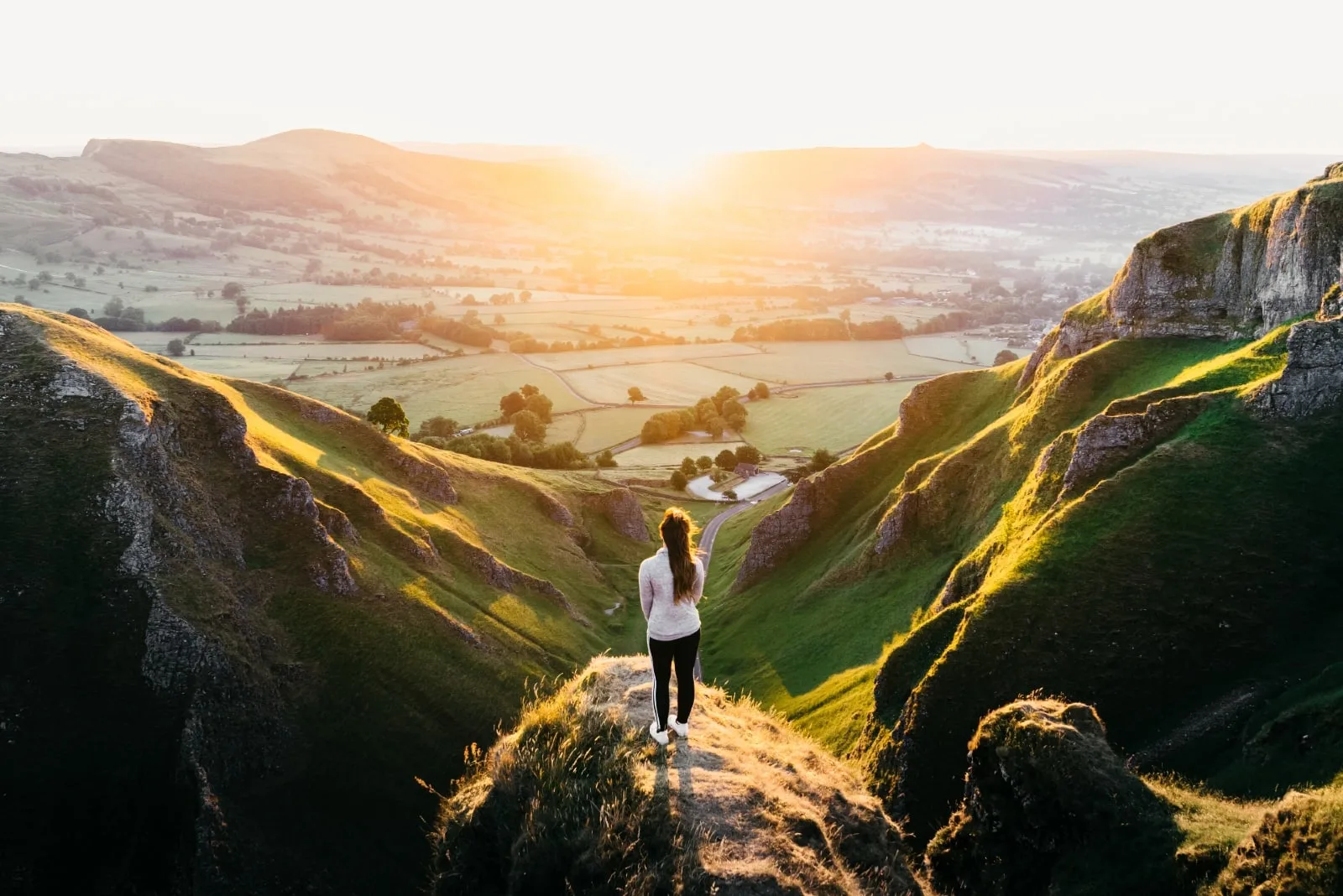 woman standing on hill during sunset