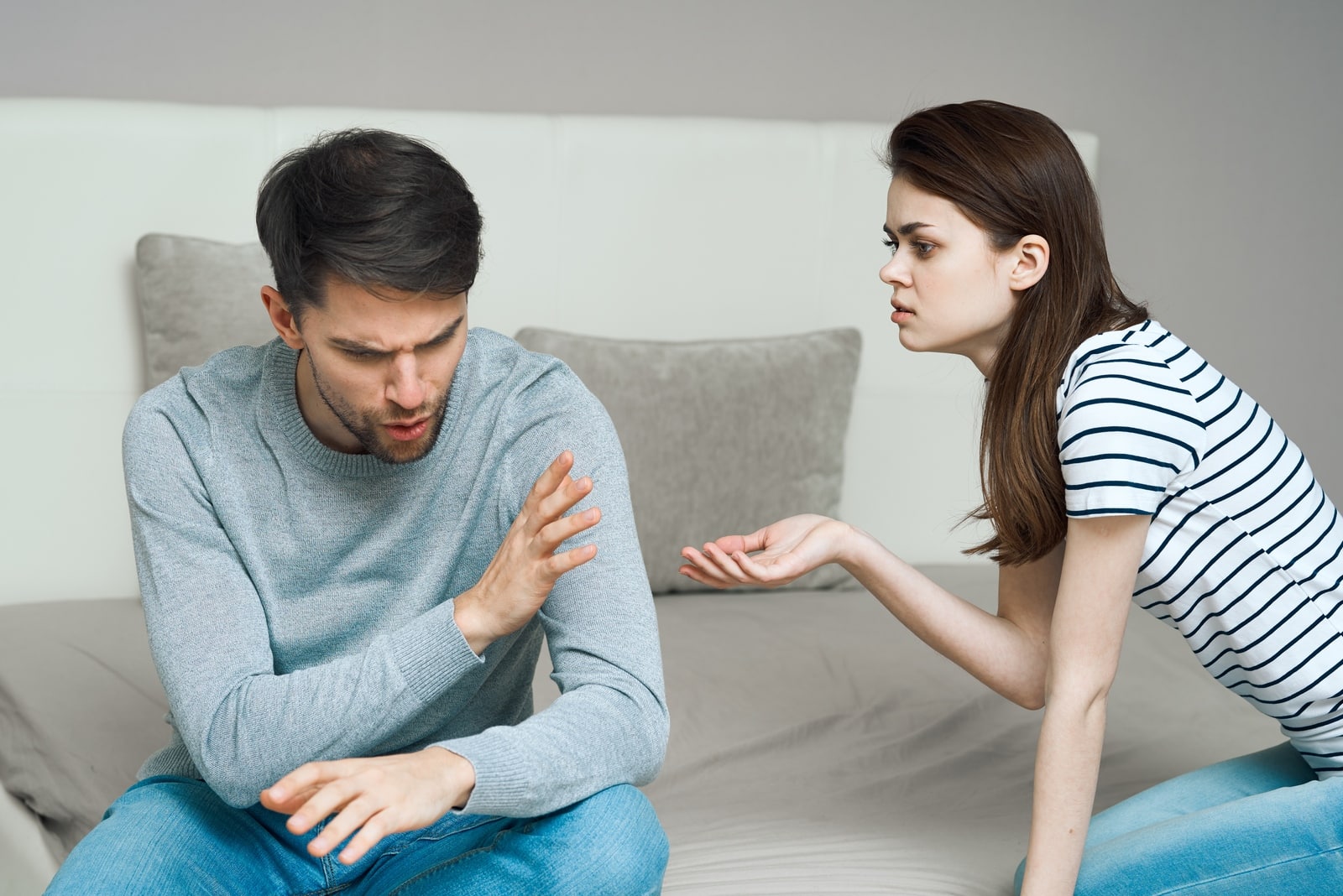 woman in striped t-shirt talking to angry man