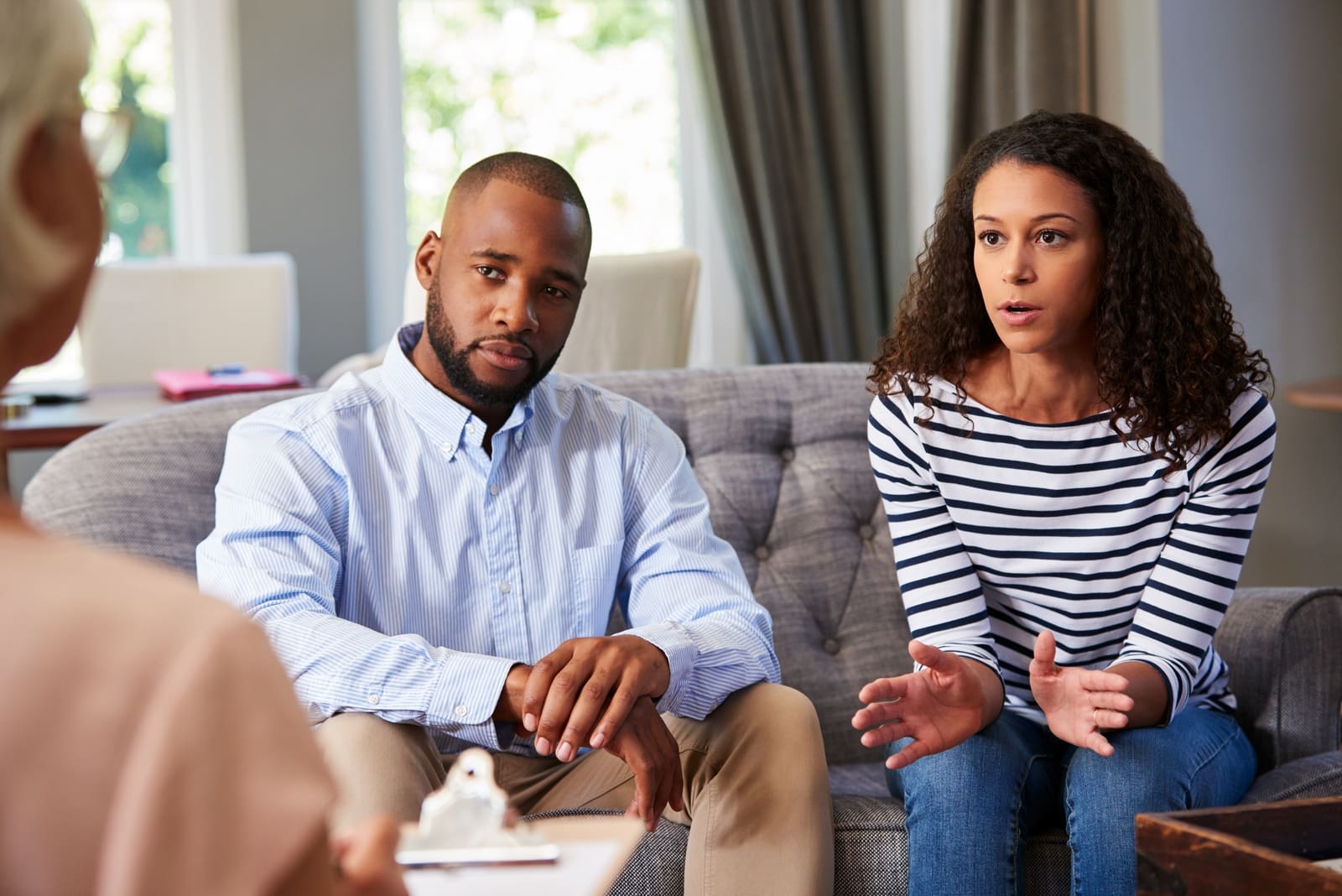 woman talking to therapist while sitting near man