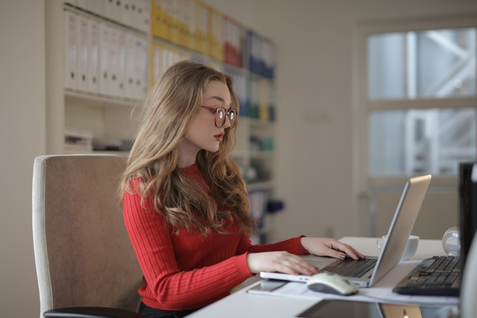 mulher com óculos a utilizar um computador portátil