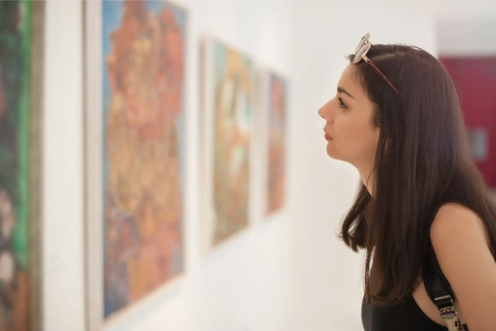 woman visiting an art gallery with arts on the wall