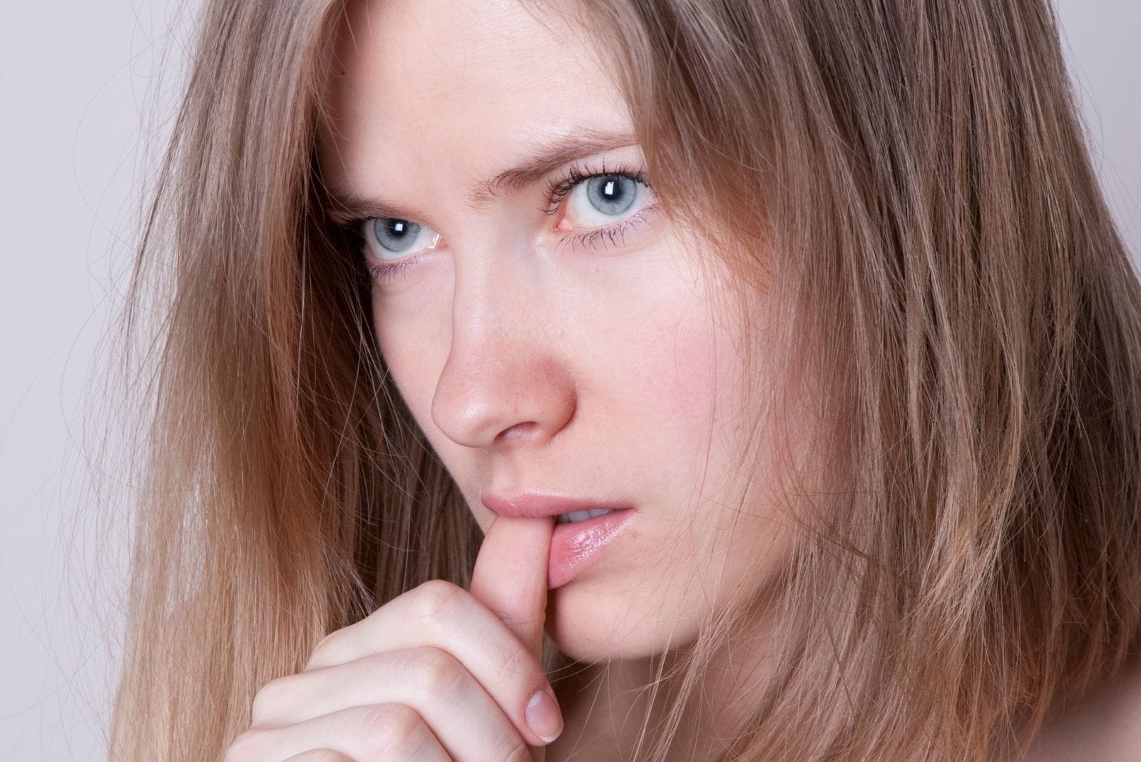 mujer con un ojo azul mirando furiosamente mordiendose el pulgar