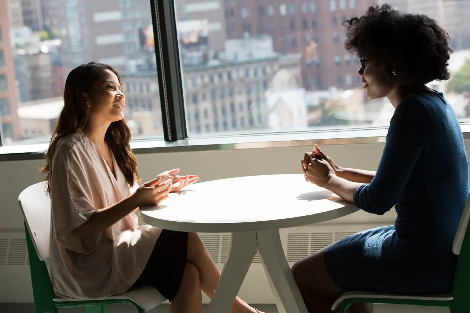 two women talking while sitting at table