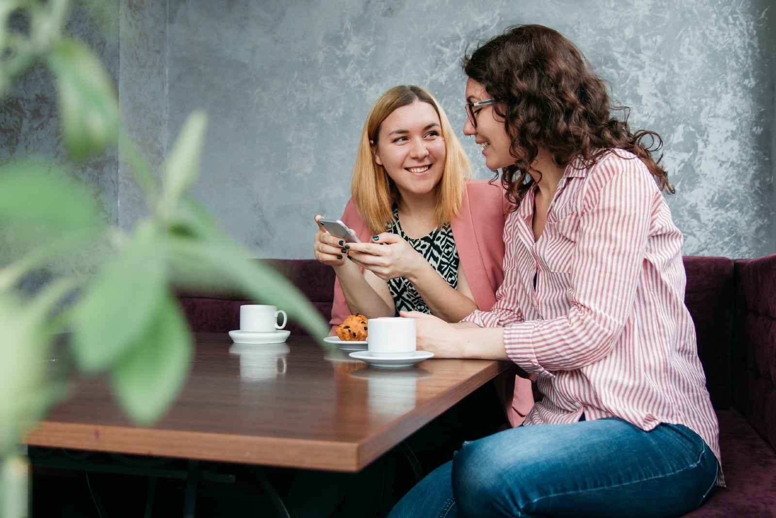 two women talking while sitting at table in cafe