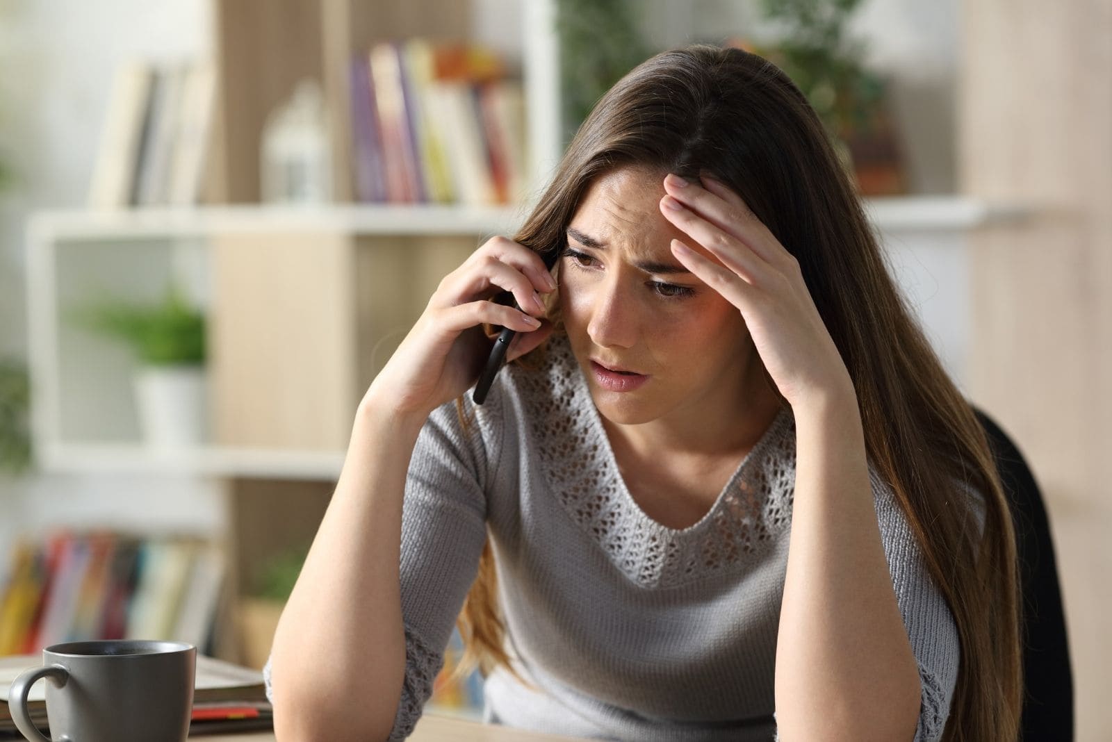 mulher preocupada a falar ao telefone na sala de estar