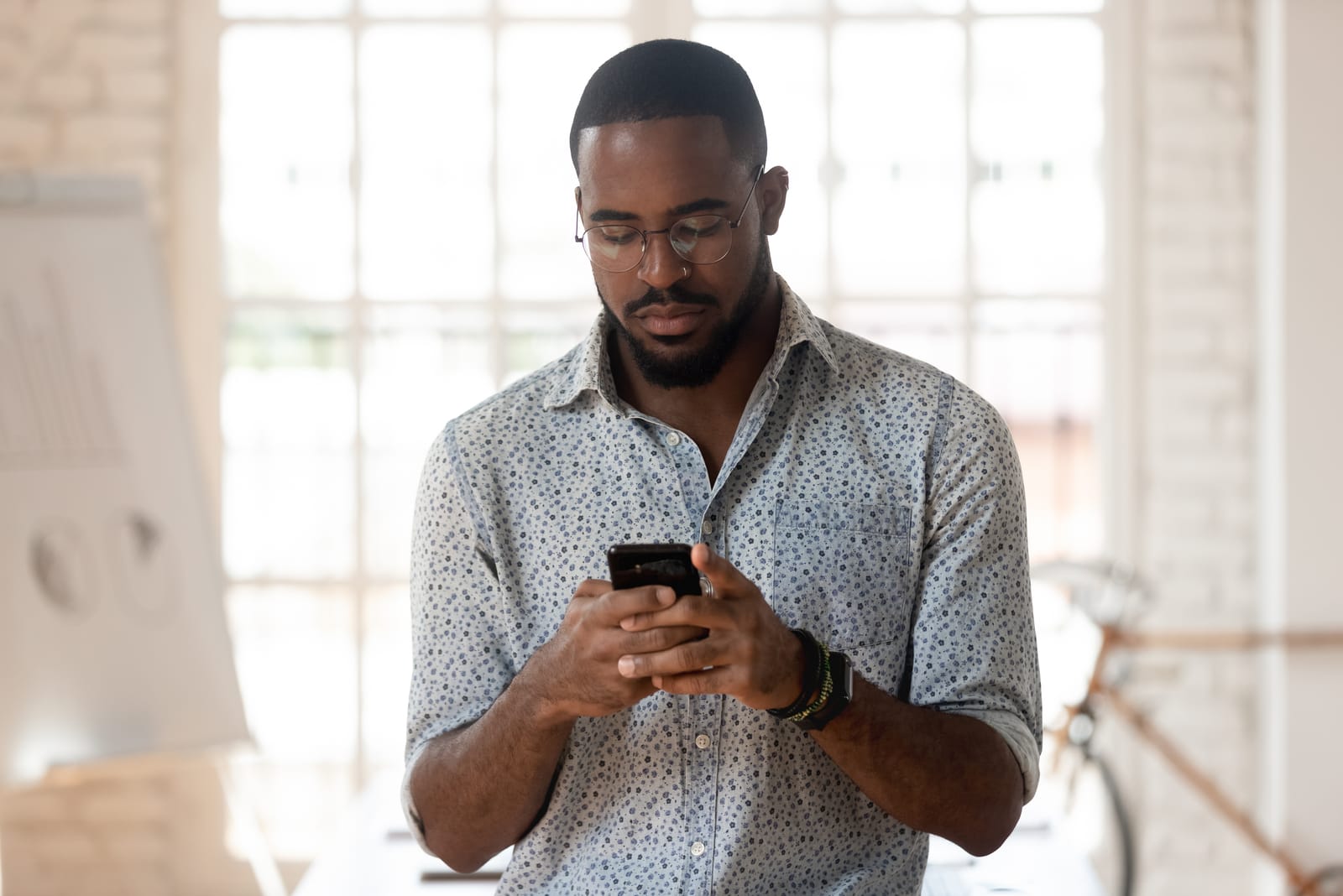 joven empleado utilizando un smartphone en la oficina