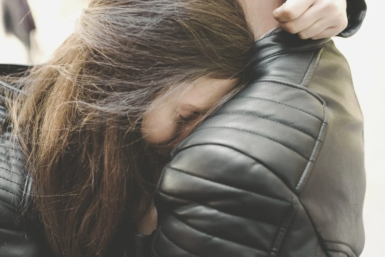 young woman embracing a man wearing a leather jacket