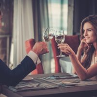 coppia romantica che si incontra in un ristorante facendo tintinnare i bicchieri di vino