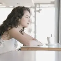 pensive woman having coffee in the morning pensively in side view
