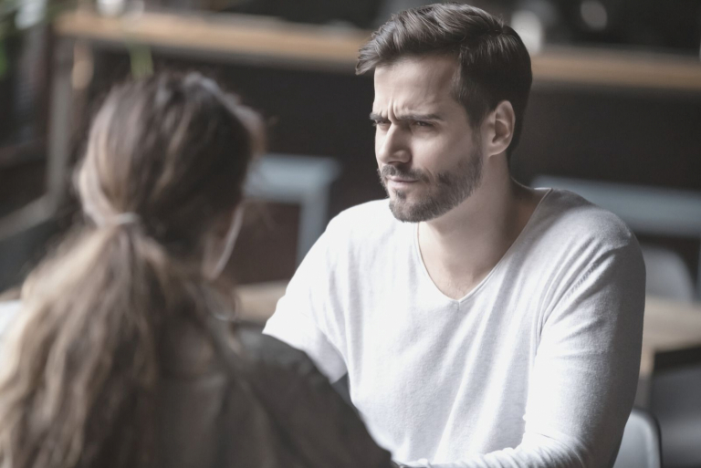 doubting man looking at the woman during a date inside the restaurant