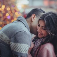 man kissing woman's neck while standing outdoor
