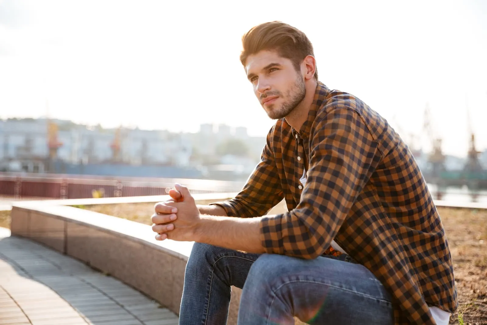 Pensive young man in plaid shirt