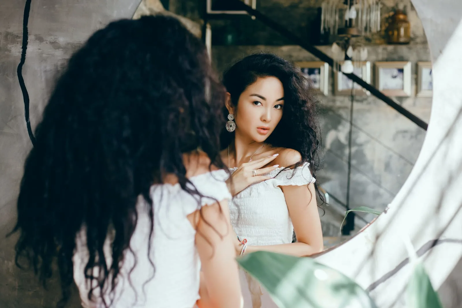 a beautiful asian woman looks in the mirror
