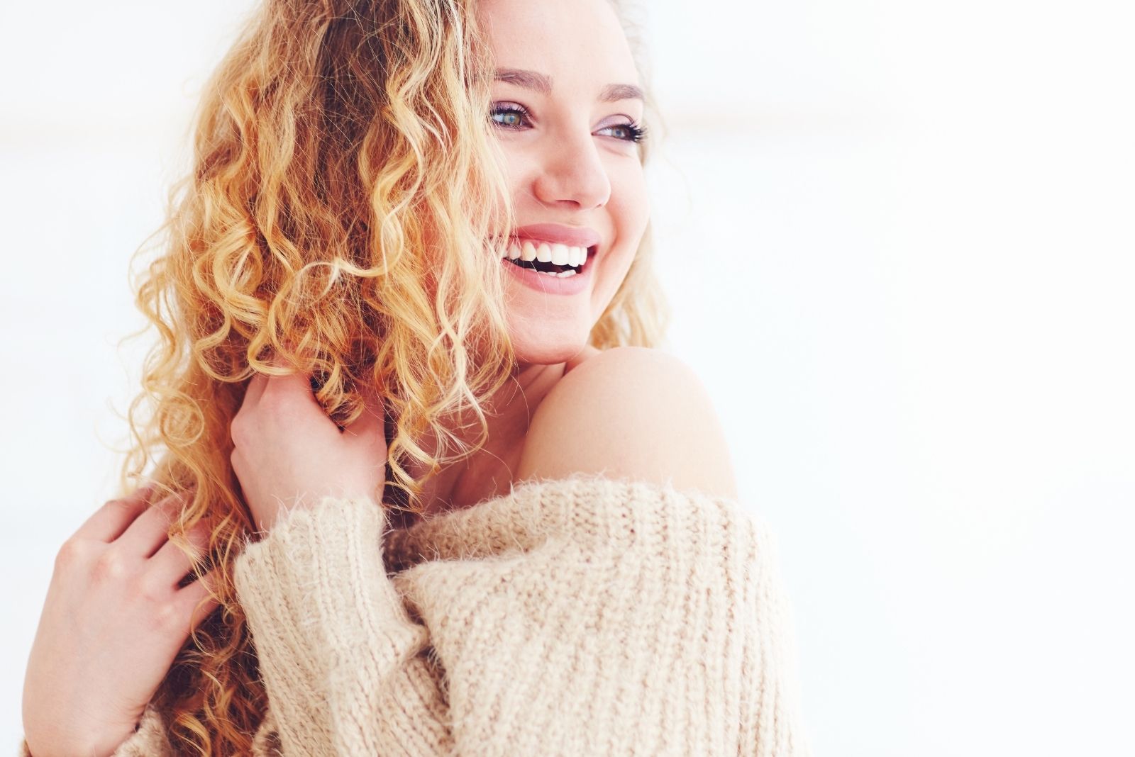 beautiful happy woman with curly blonde hair smiling 