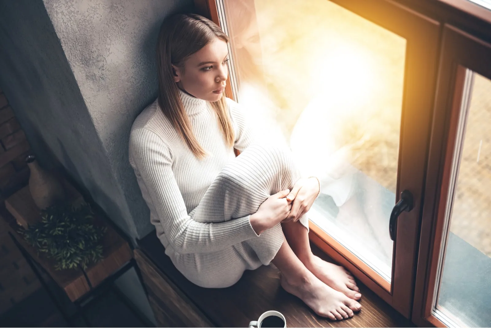 beautiful young woman looking through window