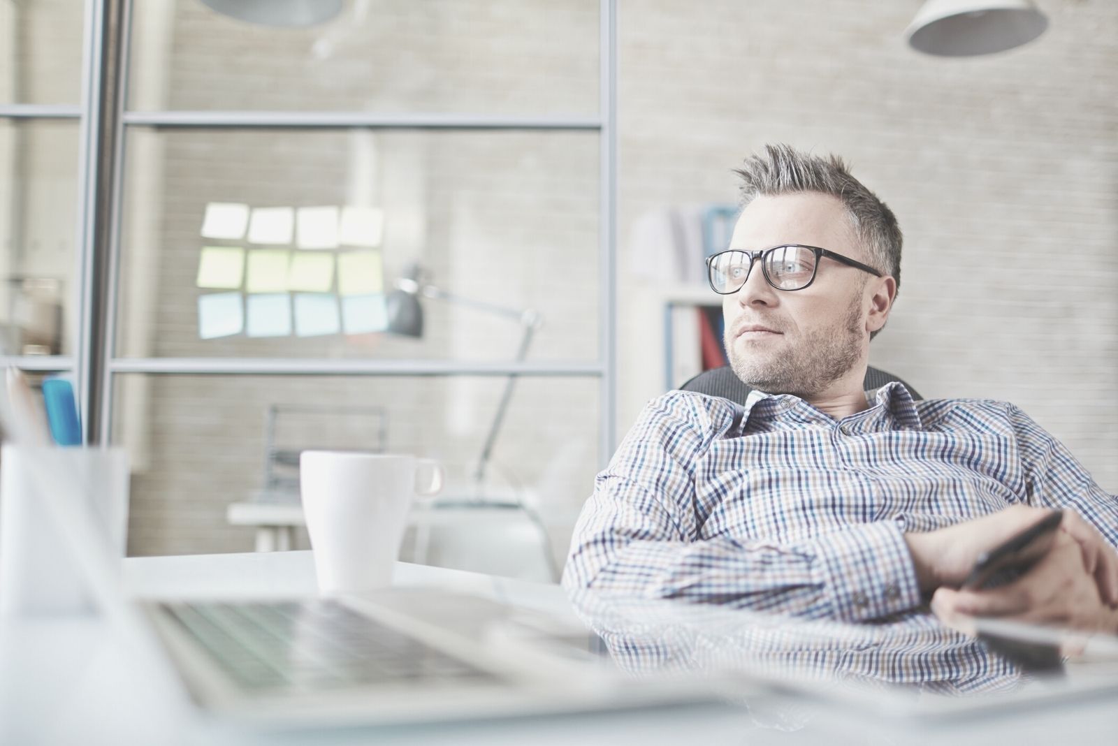 calm businessman sitting in the chair inside his office thinking deeply