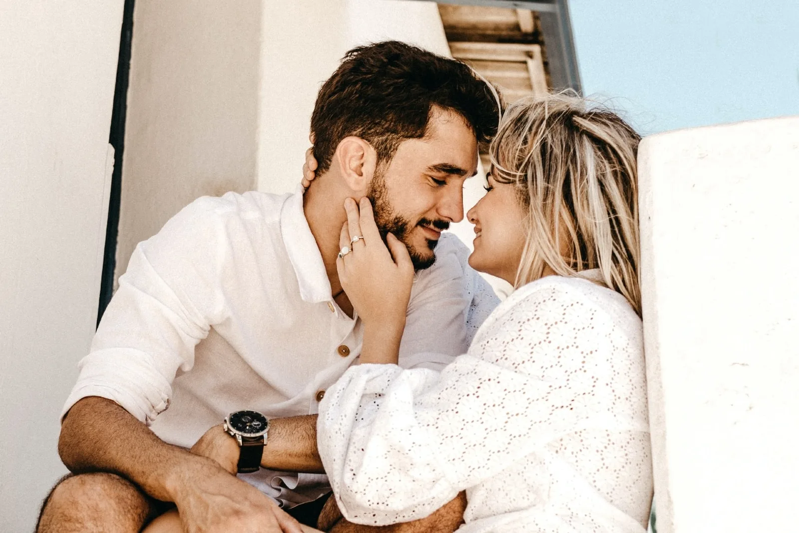man and woman about to kiss while sitting outdoor