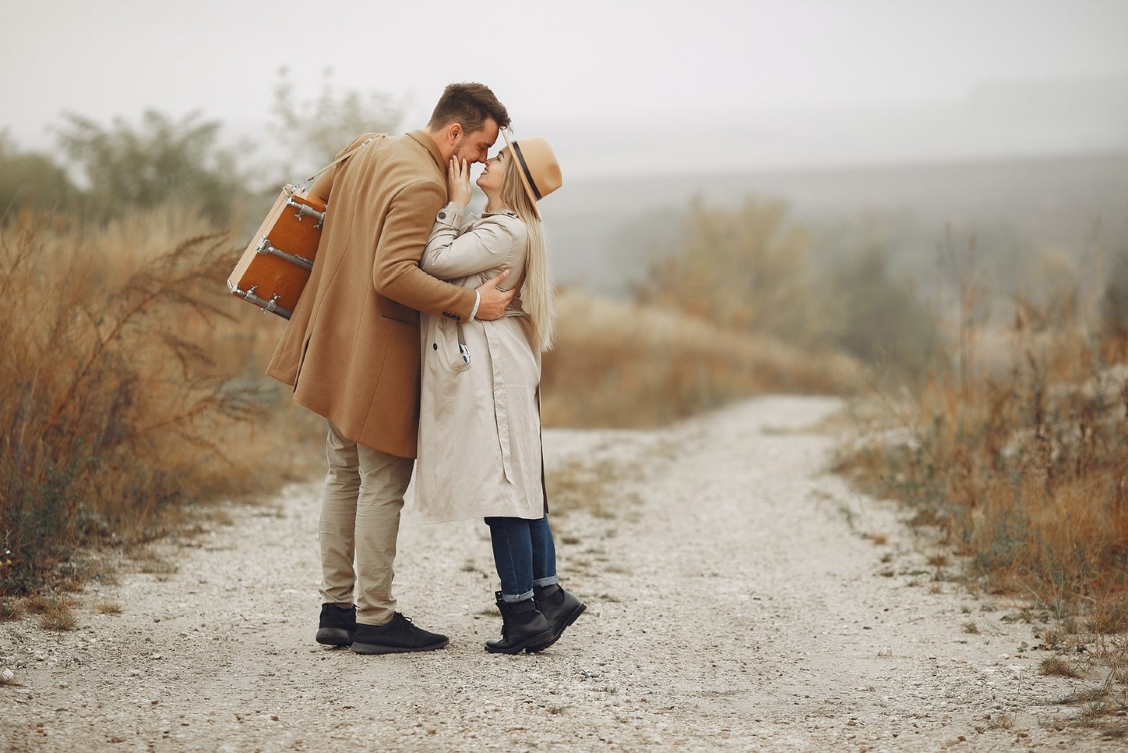 uomo e donna in procinto di baciarsi in piedi su un sentiero rurale