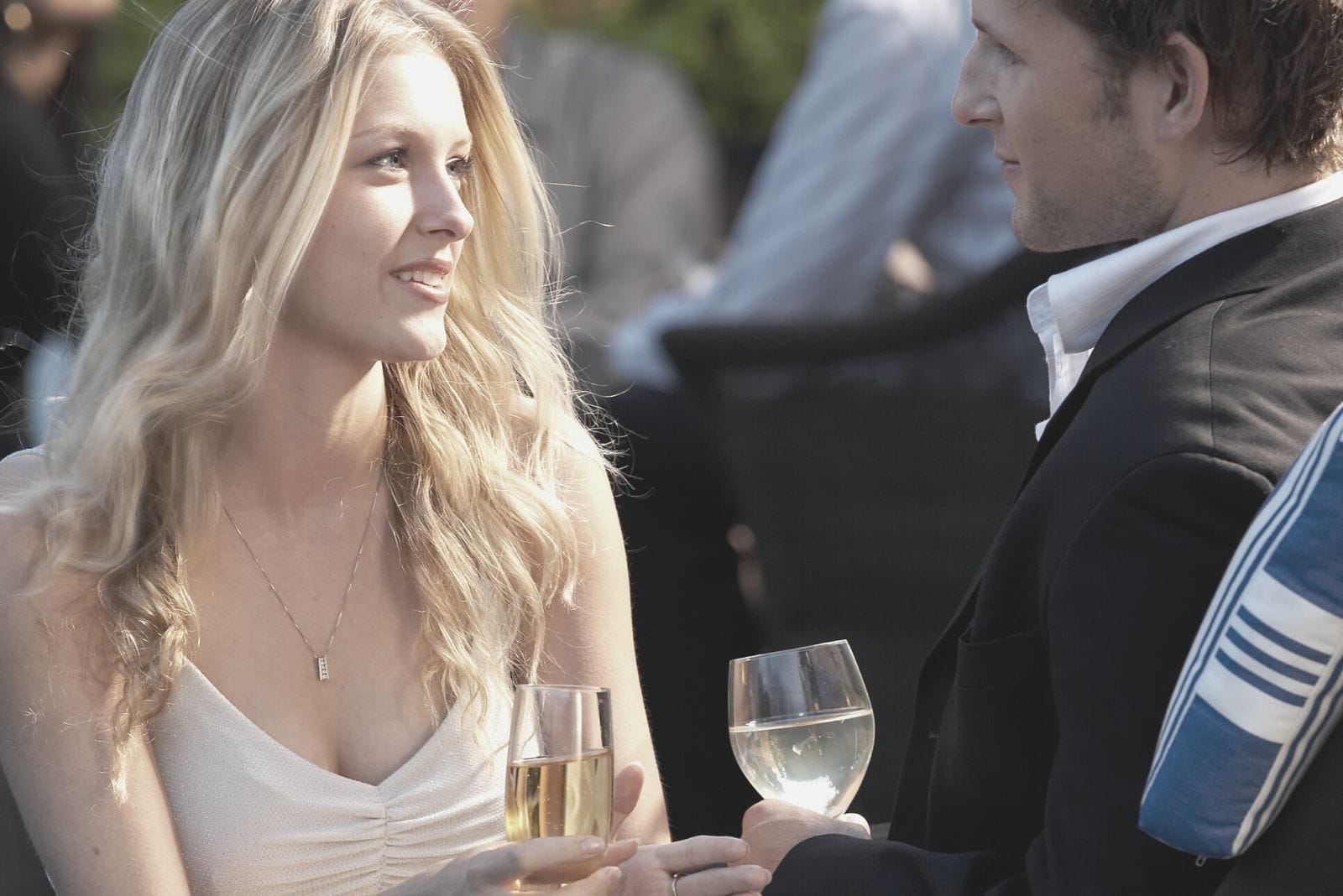 couple attending a party wearing formal dress and drinking wine