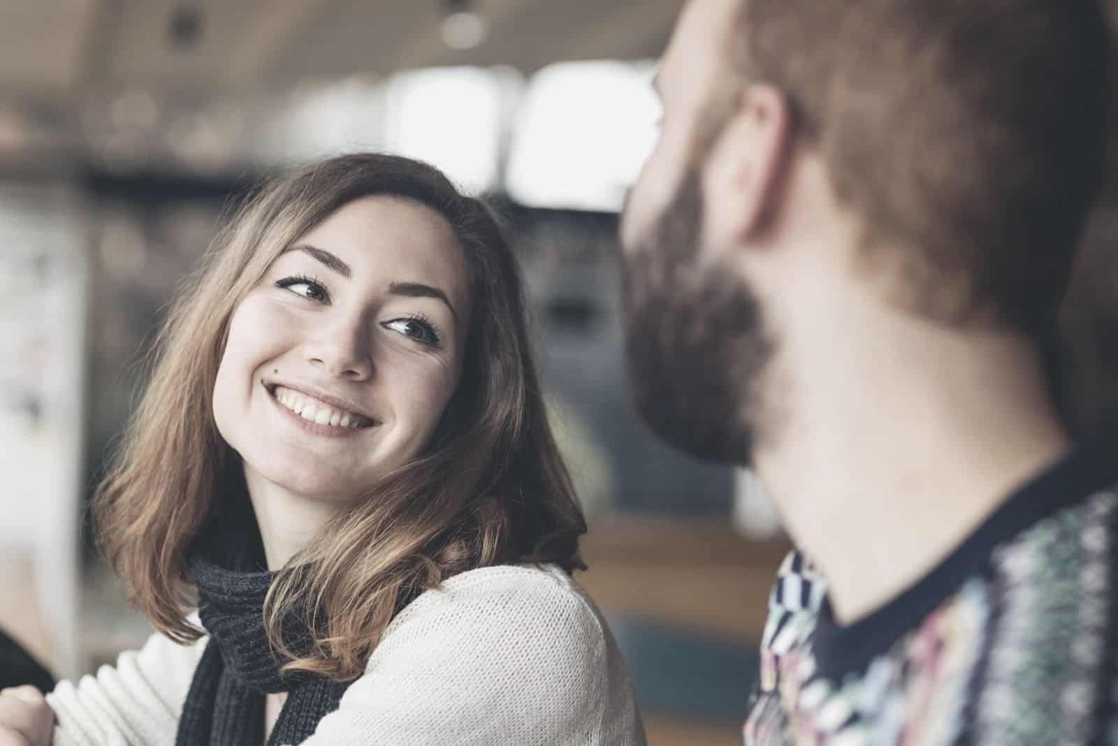 couple having a great time looking at each other sitting indoors