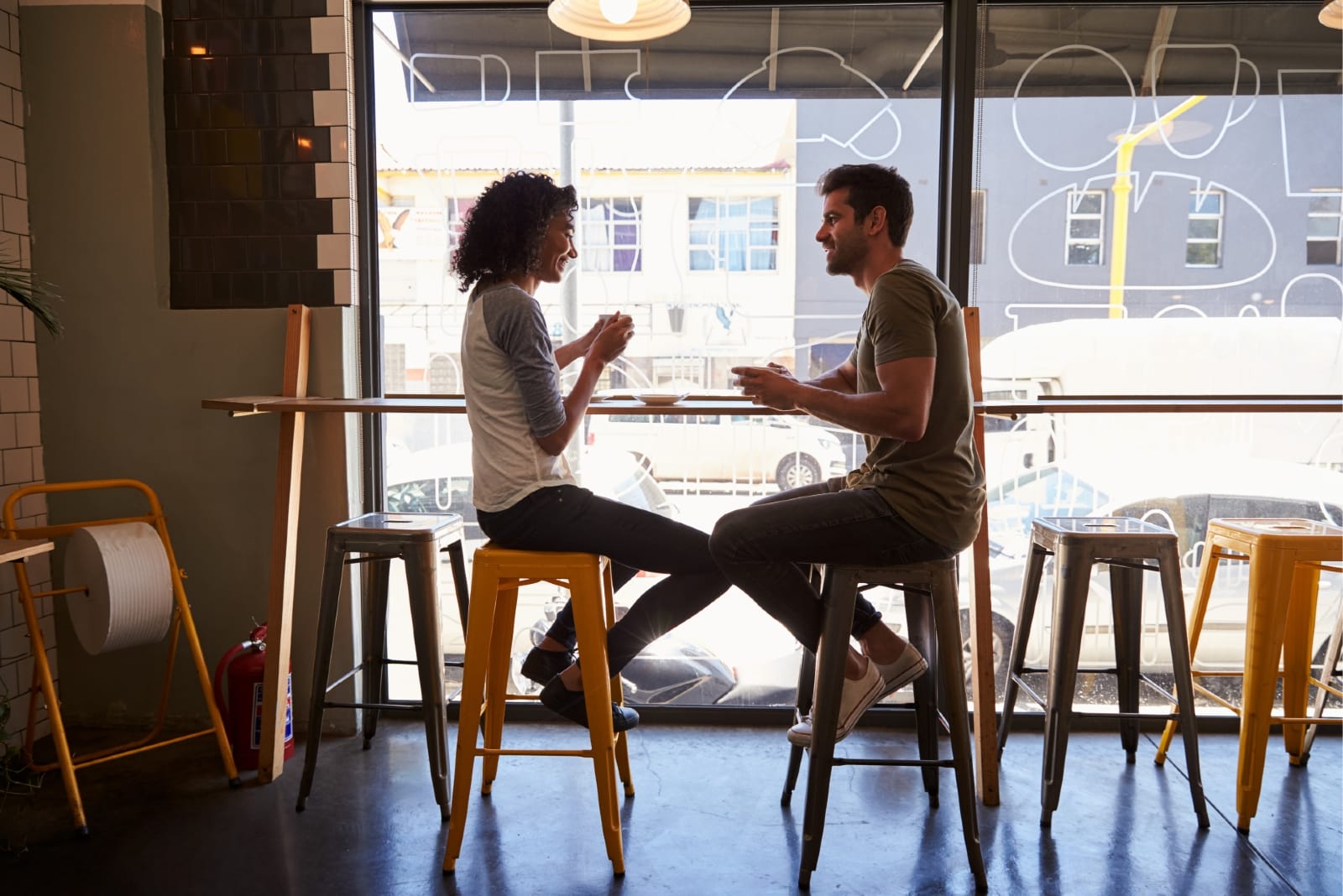 hombre y mujer tomando cafe sentados en una cafeteria