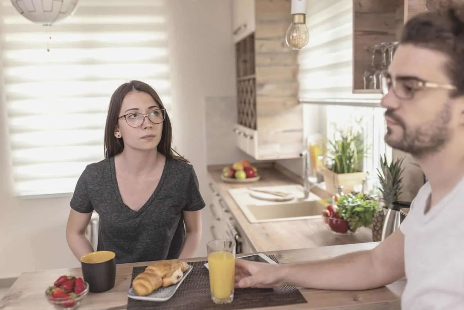 couple having serious conversation while having breakfast in the kitchen