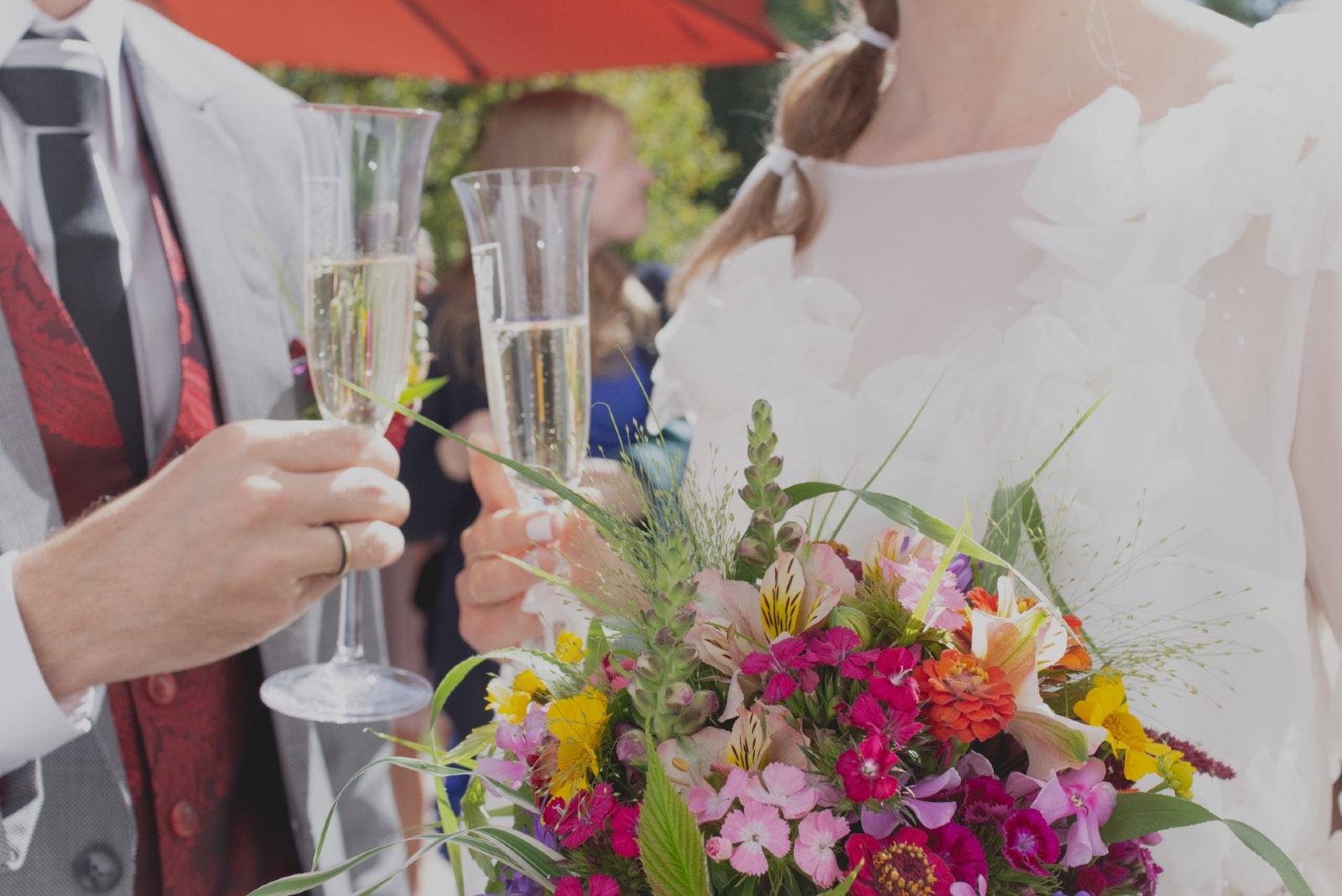 groom and bride holding glasses with champagne