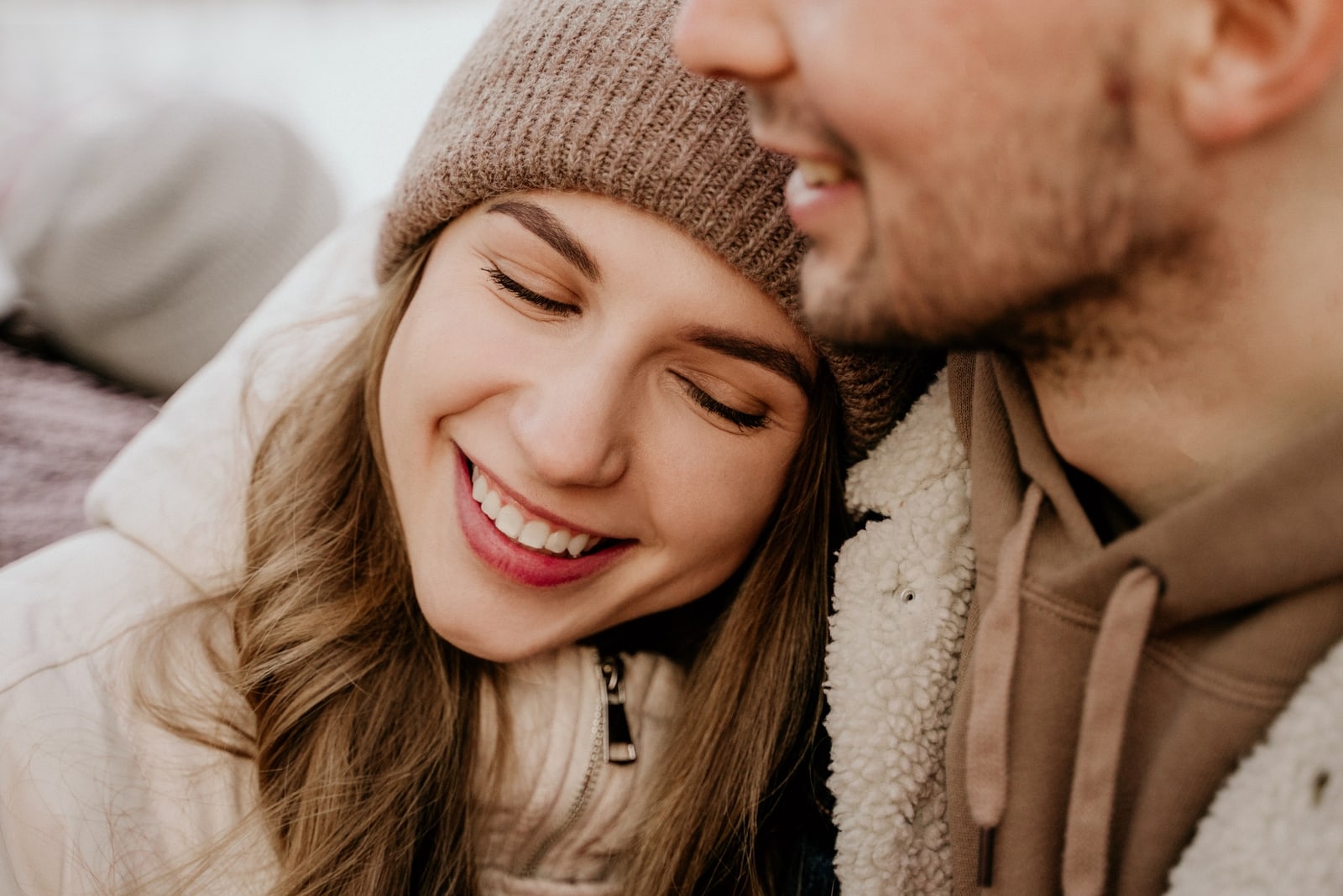 woman in brown knit cap and man hugging