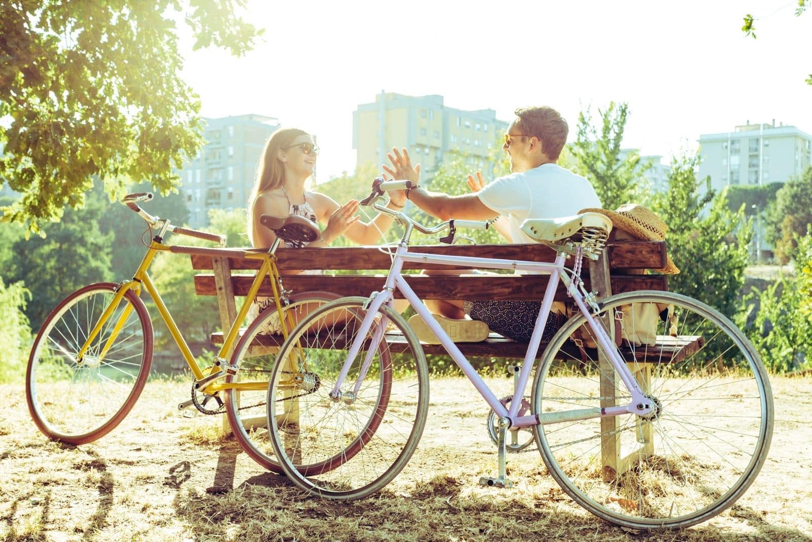 coppia che si riposa in una panchina con due biciclette divertendosi