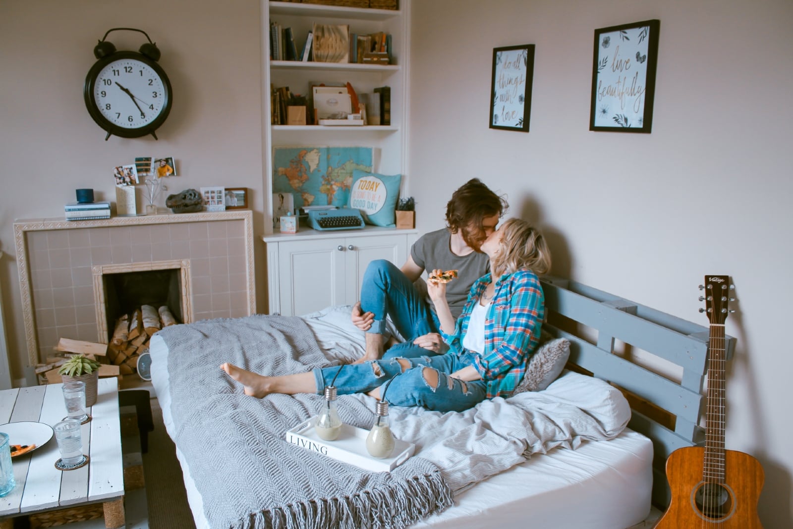 uomo e donna che si baciano seduti sul letto