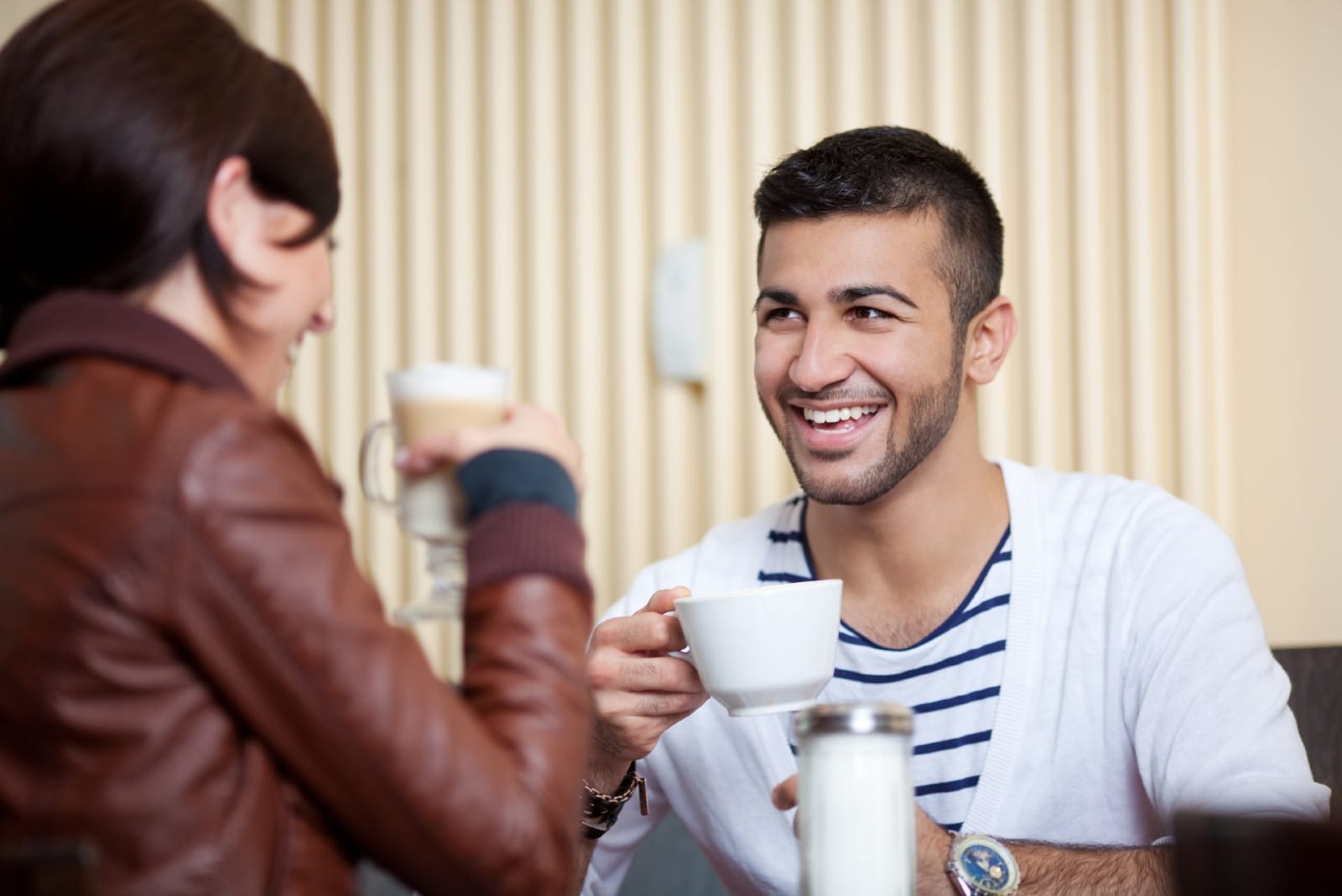 hombre y mujer sonriendo mientras toman café