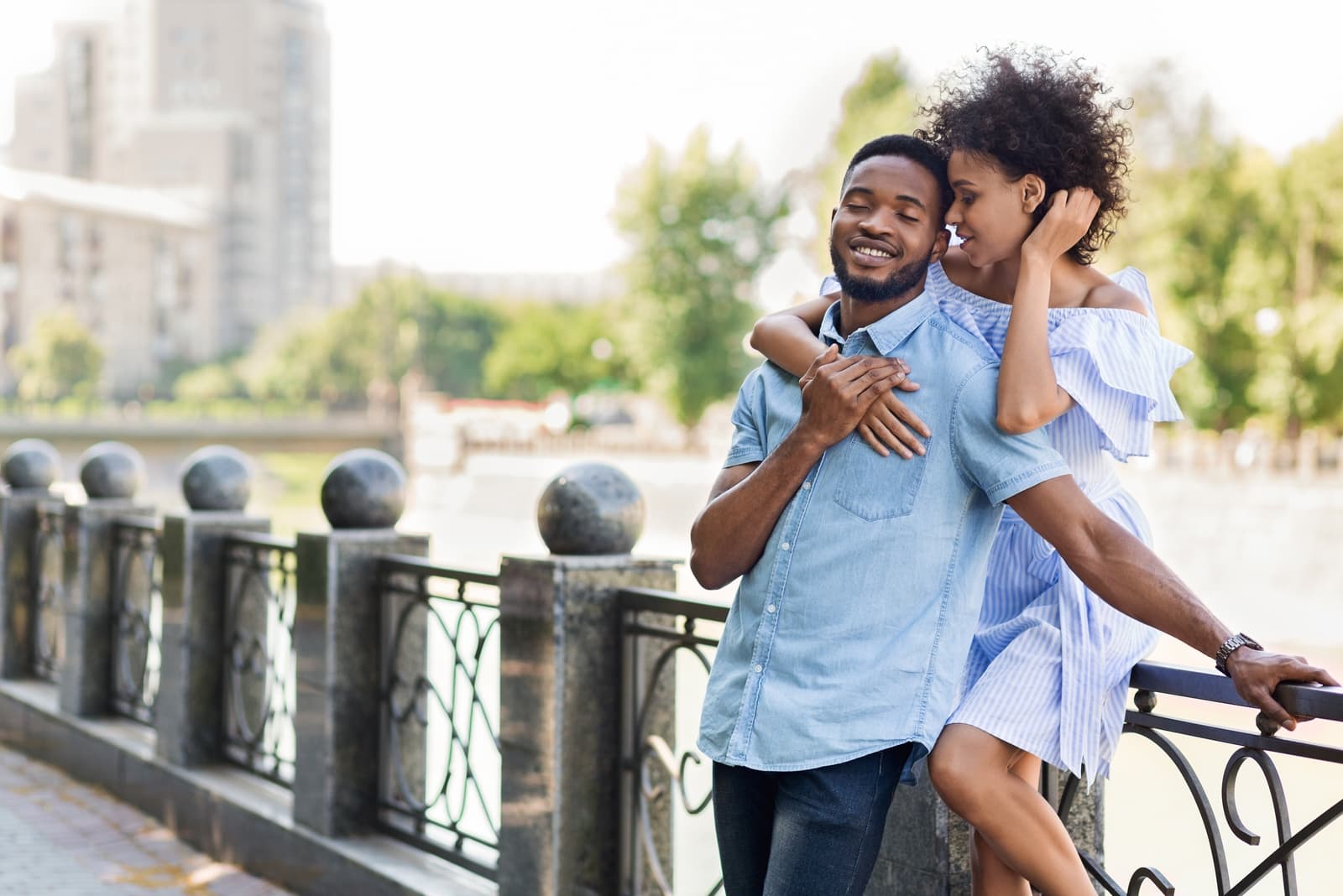 woman hugging man while standing near fence