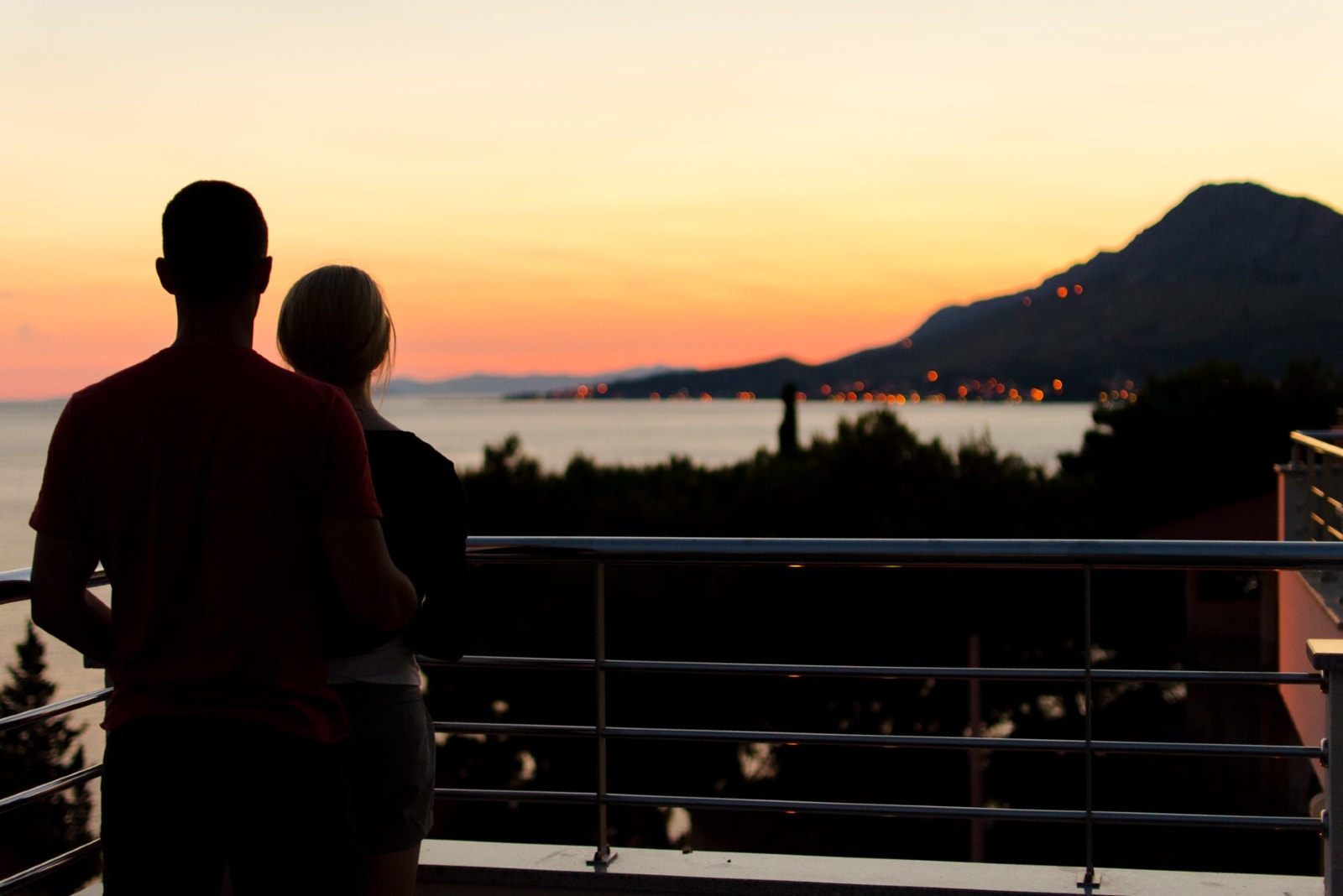 uomo e donna che si abbracciano in piedi sul balcone