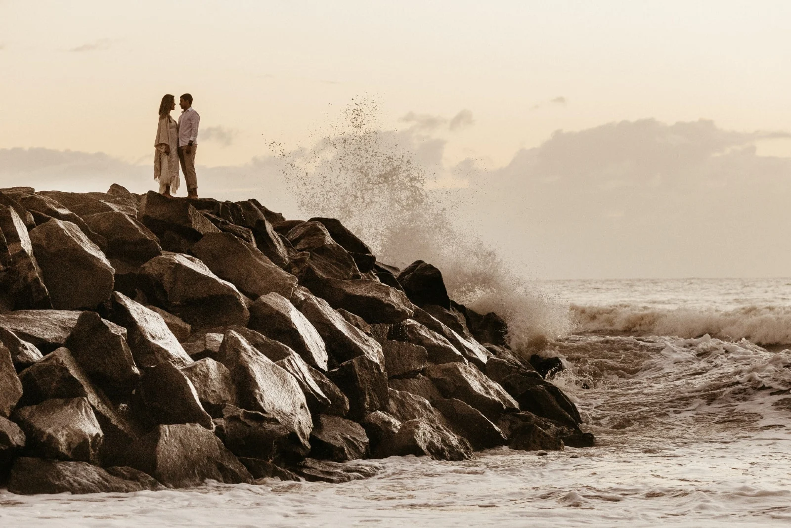 man and woman making eye contact while standing on rocks