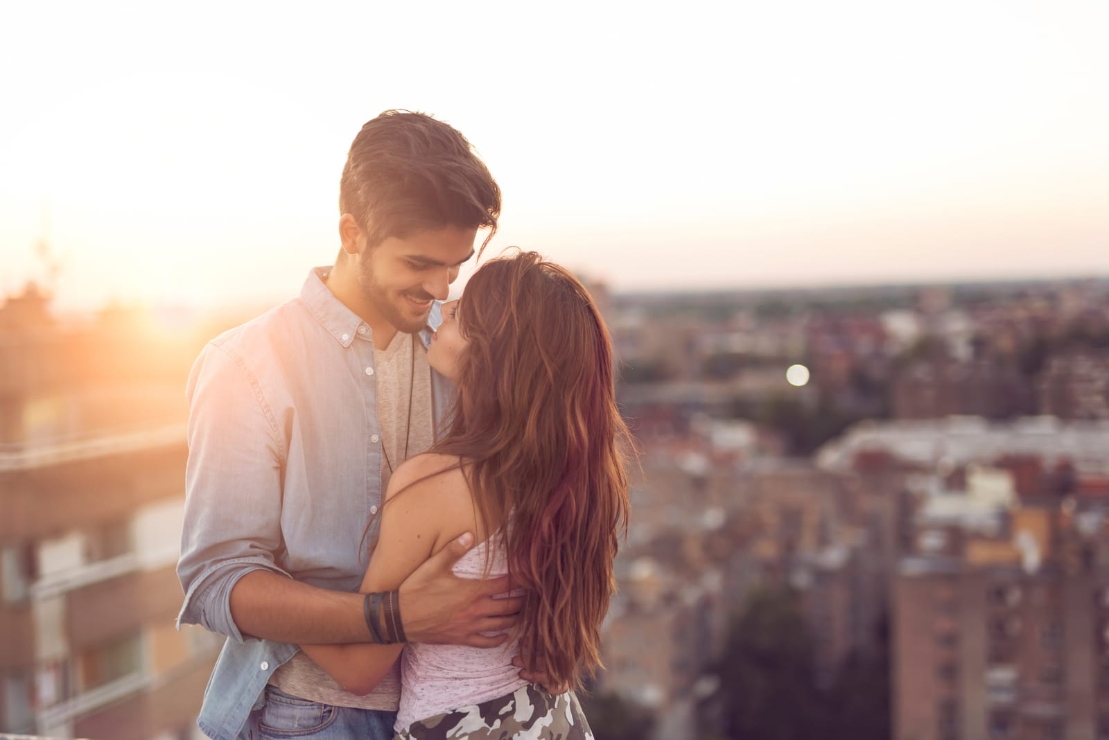 man and woman hugging while standing on rooftop