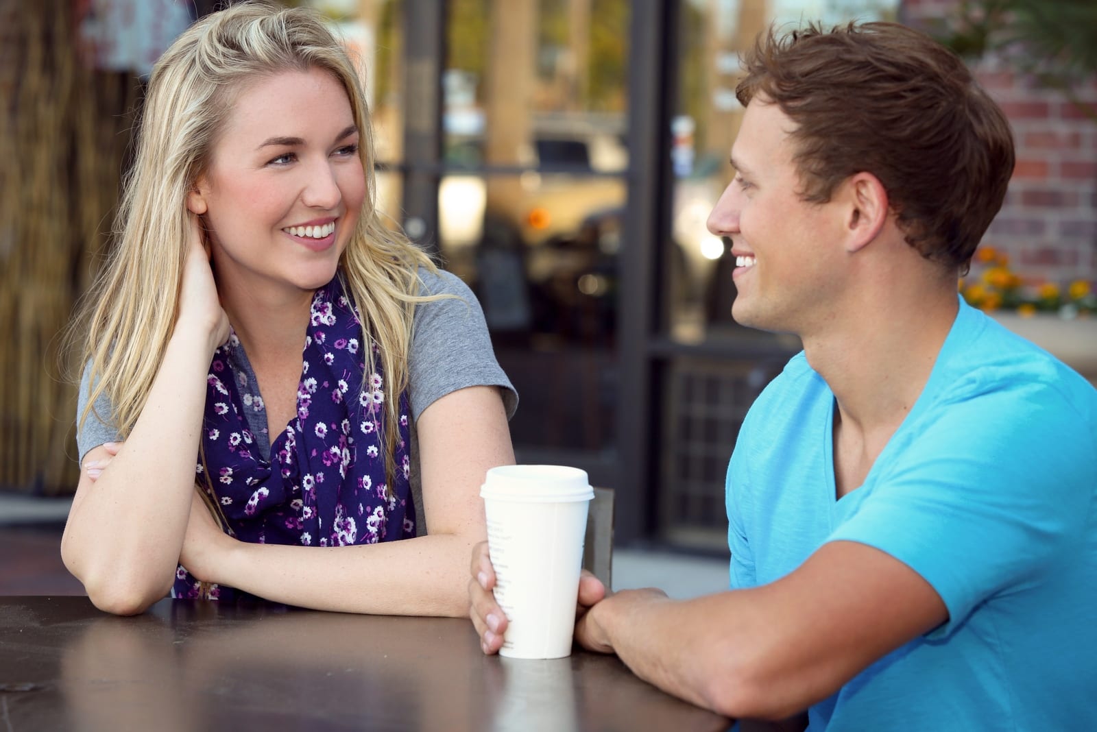  un homme et une femme qui parlent assis dans un café 