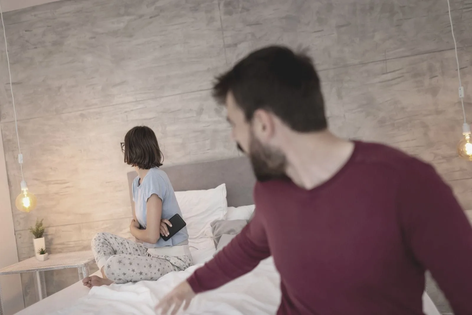 couple wearing pajamas fighting with woman turning her head away from him
