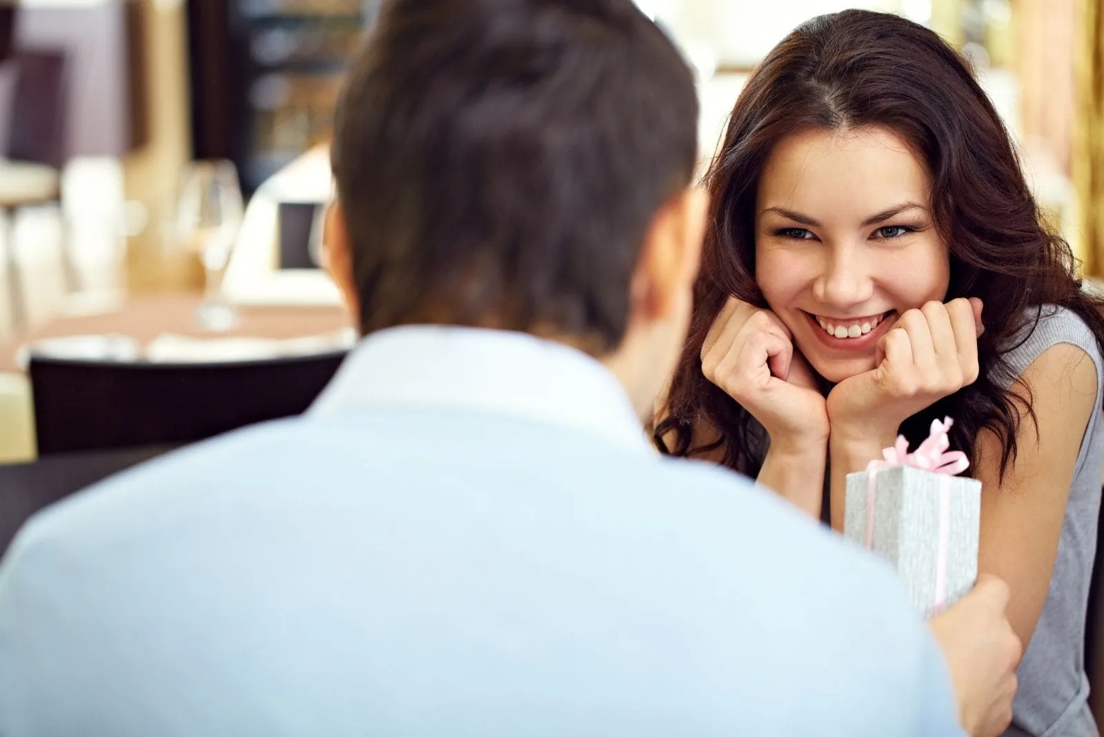 giggling beautiful woman over the gift of the man while having dinner