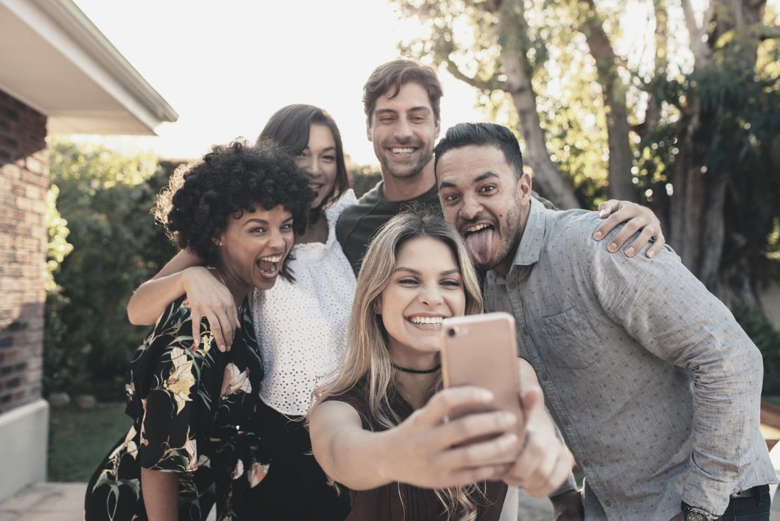 gruppo di giovani che si scattano un selfie e fanno festa