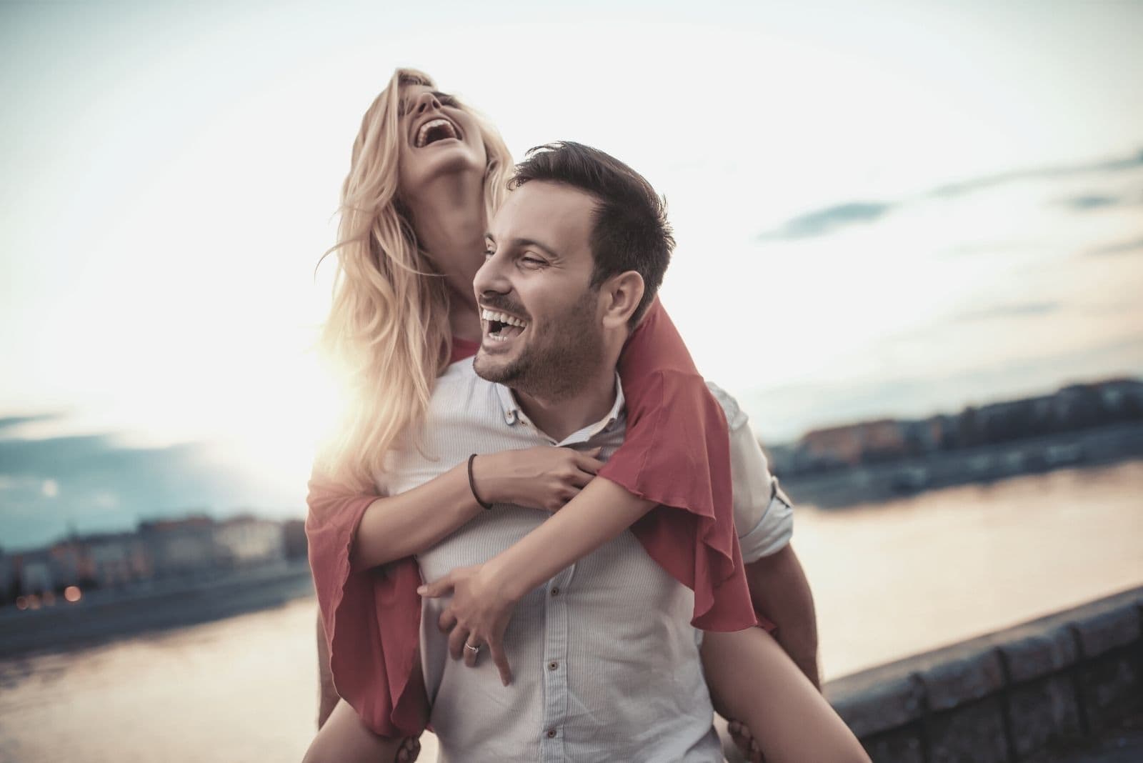 happy young couple piggyback outdoors having fun