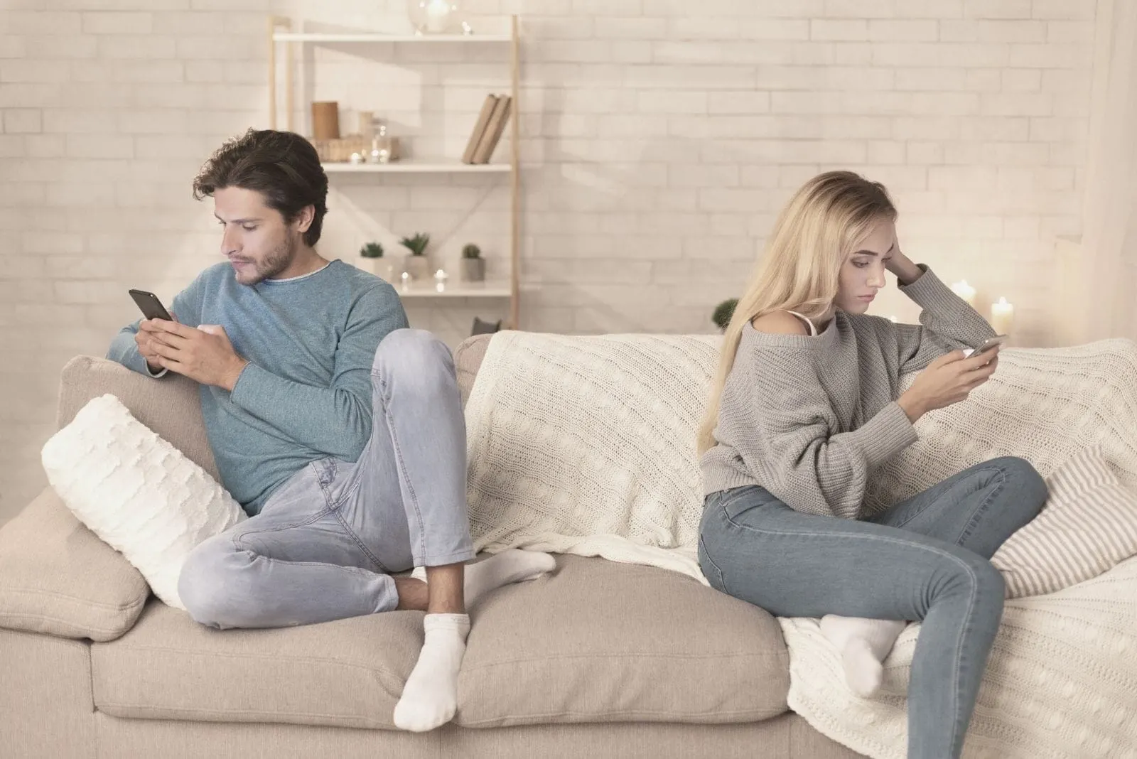 indifferent couple sitting on sofa busy with their gadget inside the livingroom