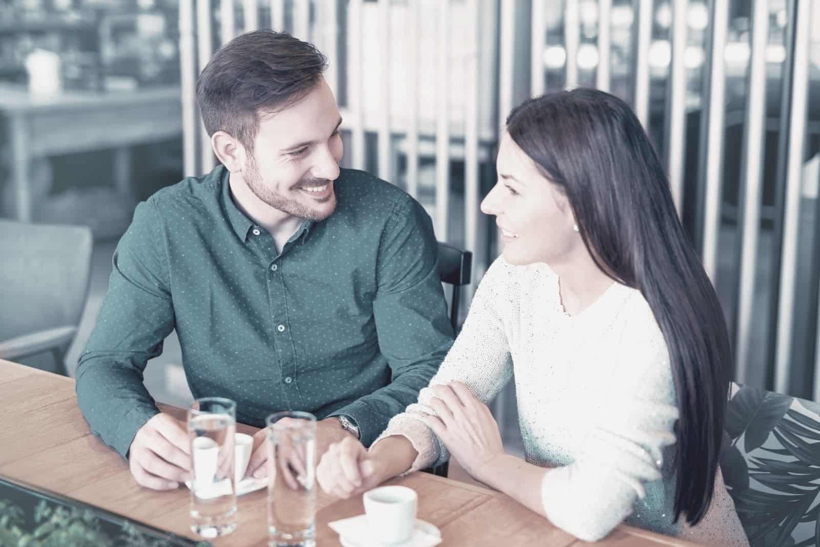 homme et femme discutant dans un café en plein air