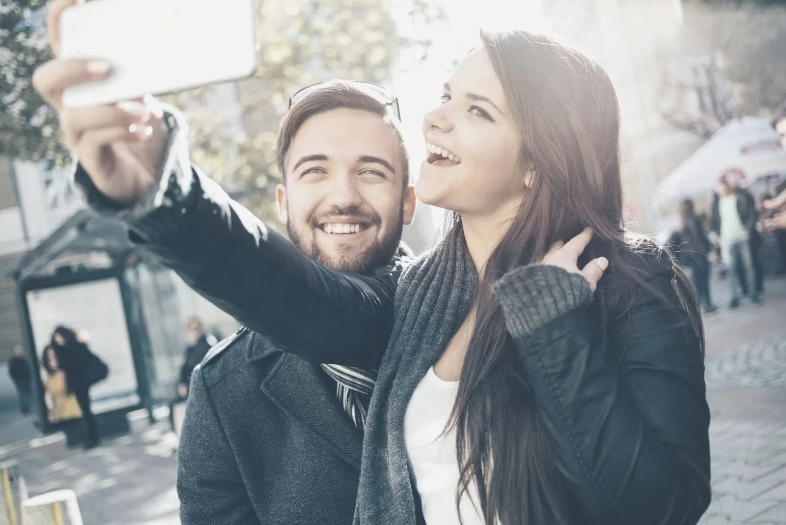 man and woman making selfie on her smartphone while walking outdoors