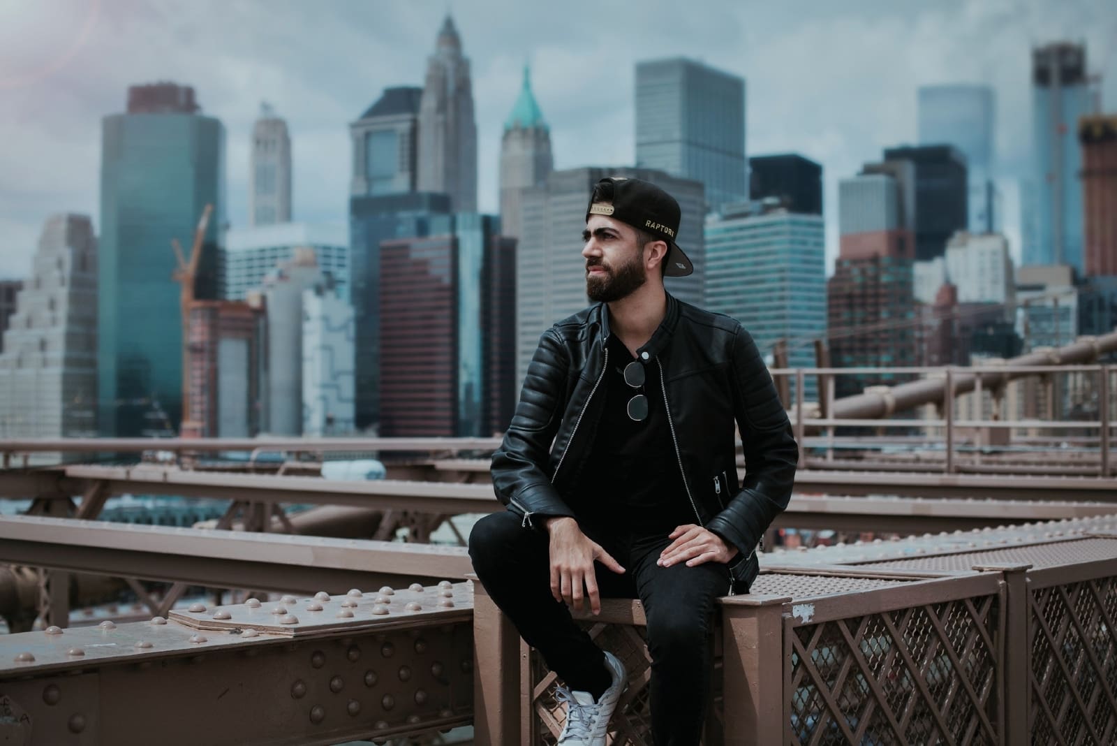 man in black jacket sitting on metal surface