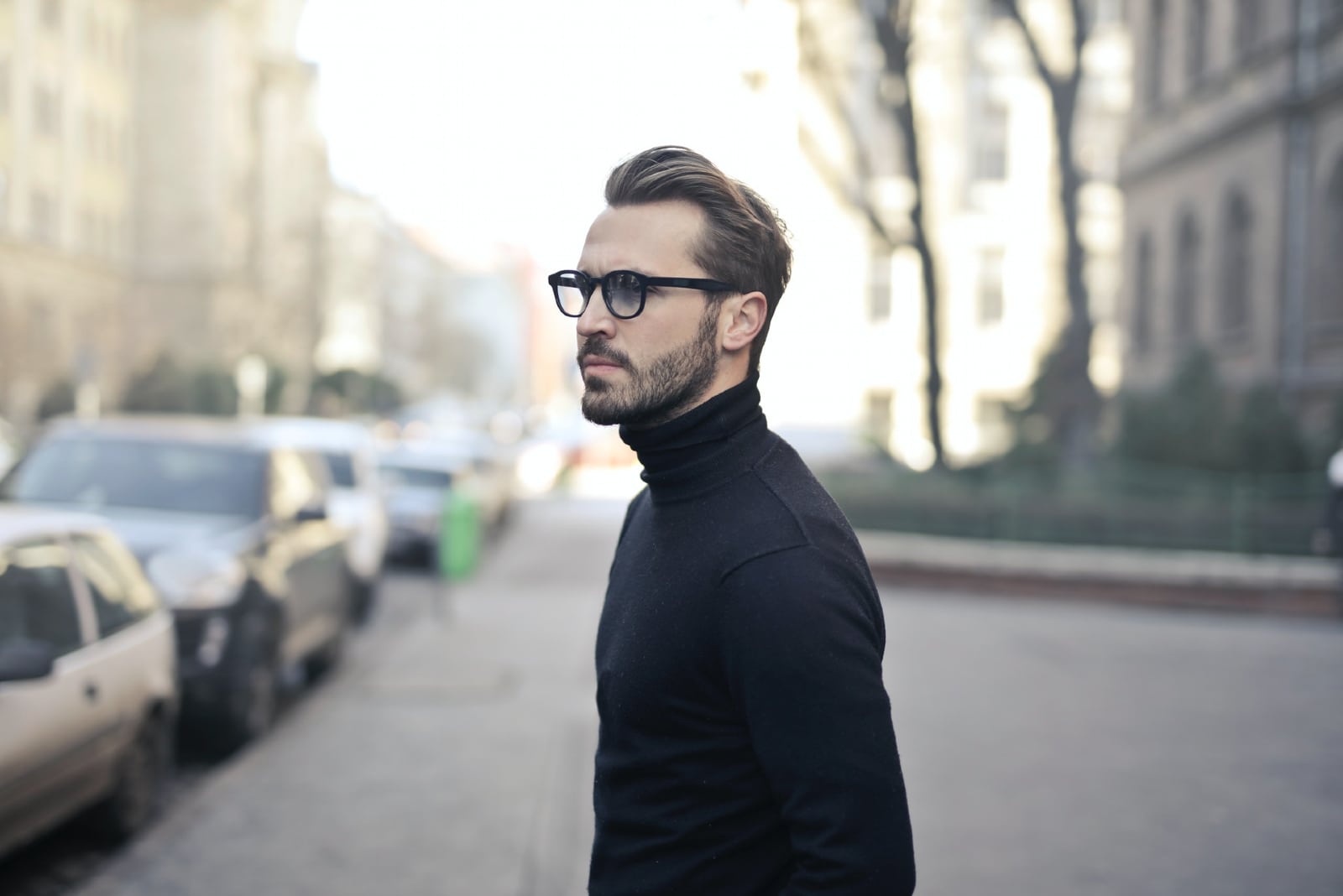 man in black turtleneck shirt standing on the street