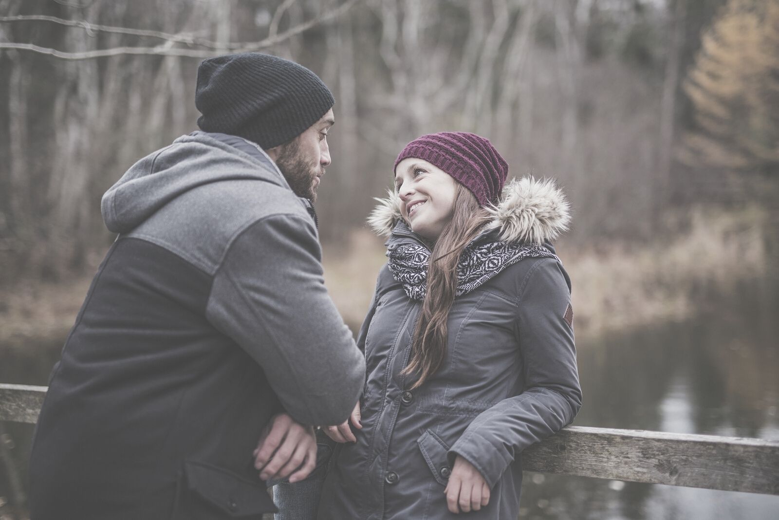 man talking to his girlfriend outdoors during fall wearing thick jackets