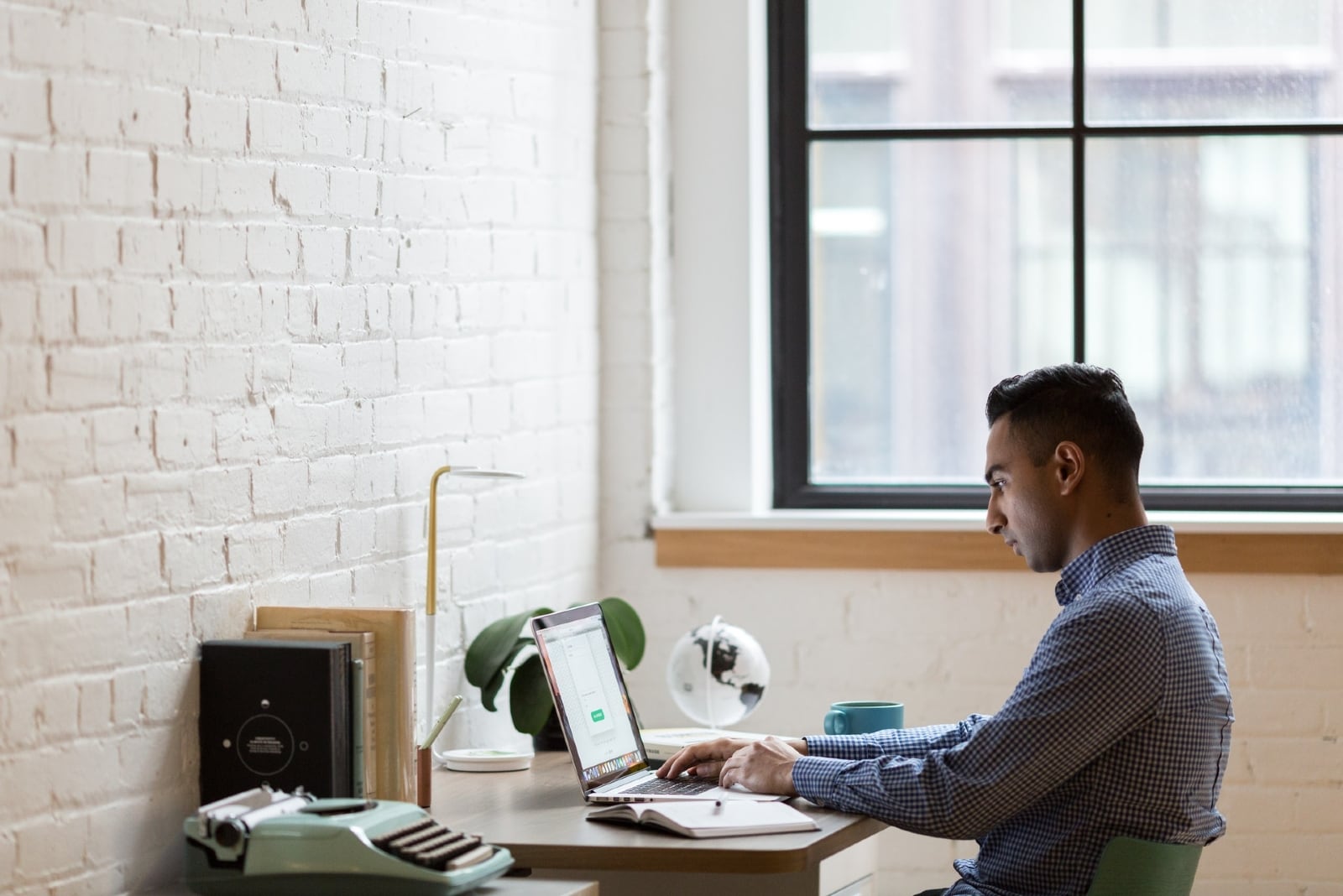 homem a utilizar um computador portátil enquanto está sentado no escritório