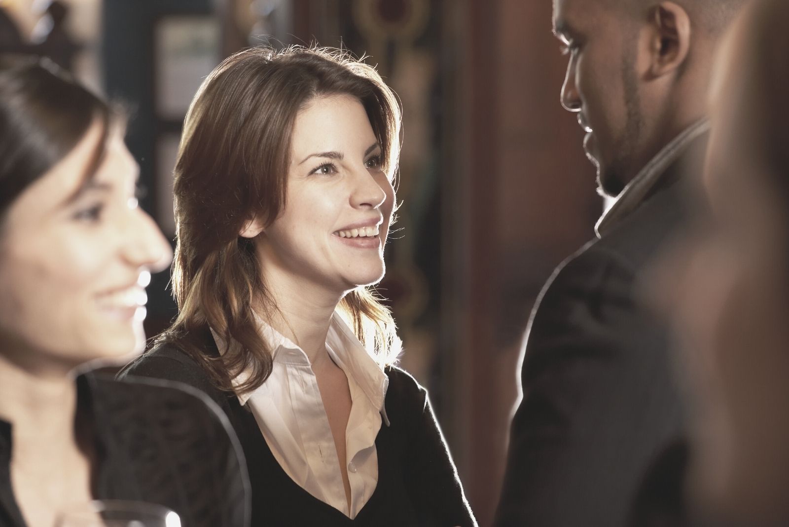 multicultural couple talking in crowd in business office wear