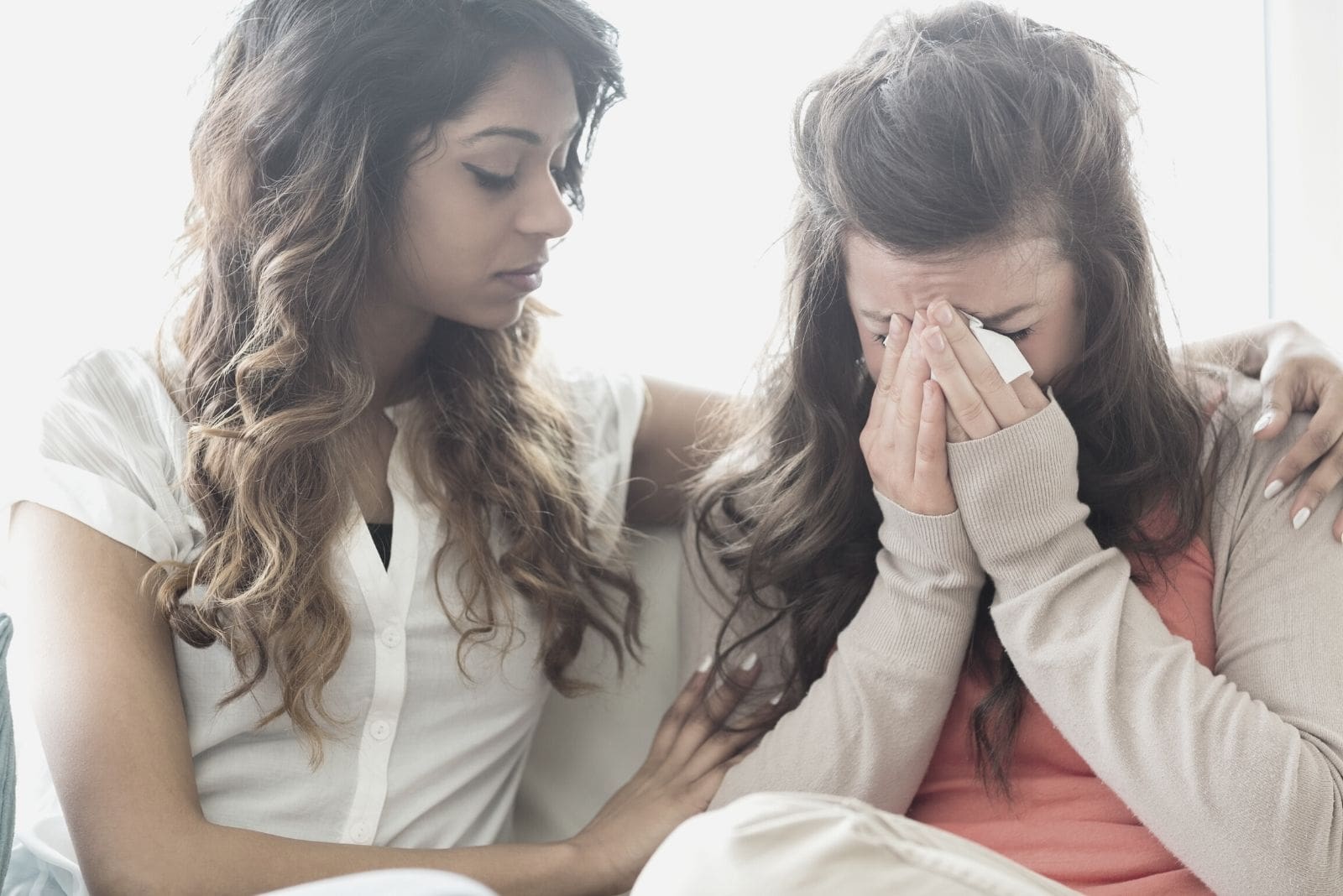 one friend crying over tissue and one friend comforting