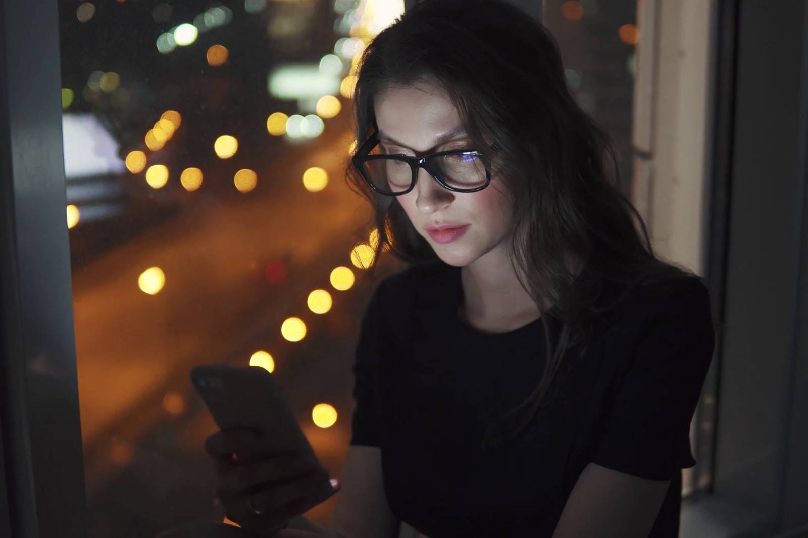 portrait of a young girl in the light of the smartphone screen